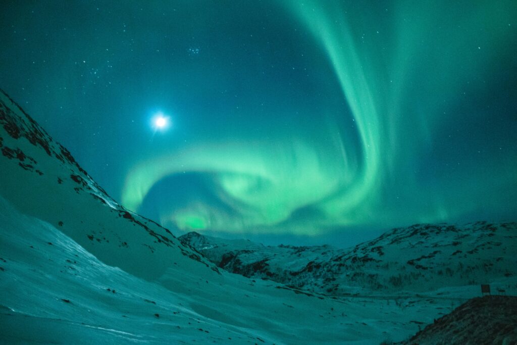 Aurora Borealis in the mountains on a moon lit night.