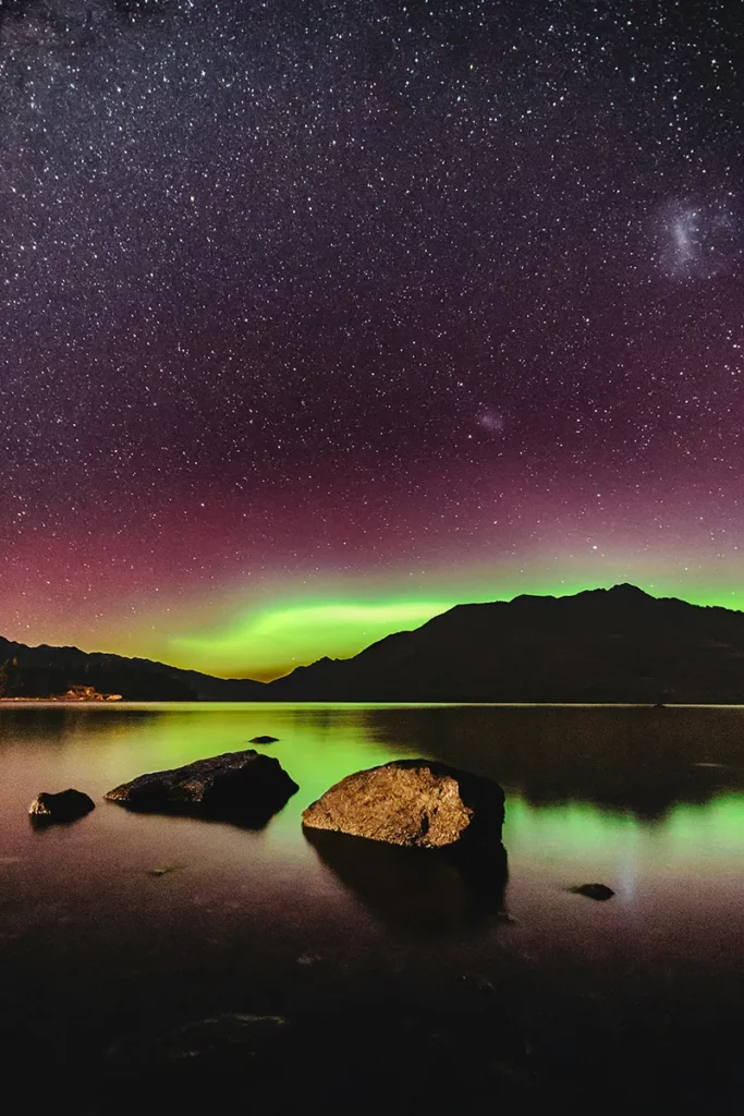The Aurora Australis sites on the horizon with a green glow in Queenstown, Newzealand