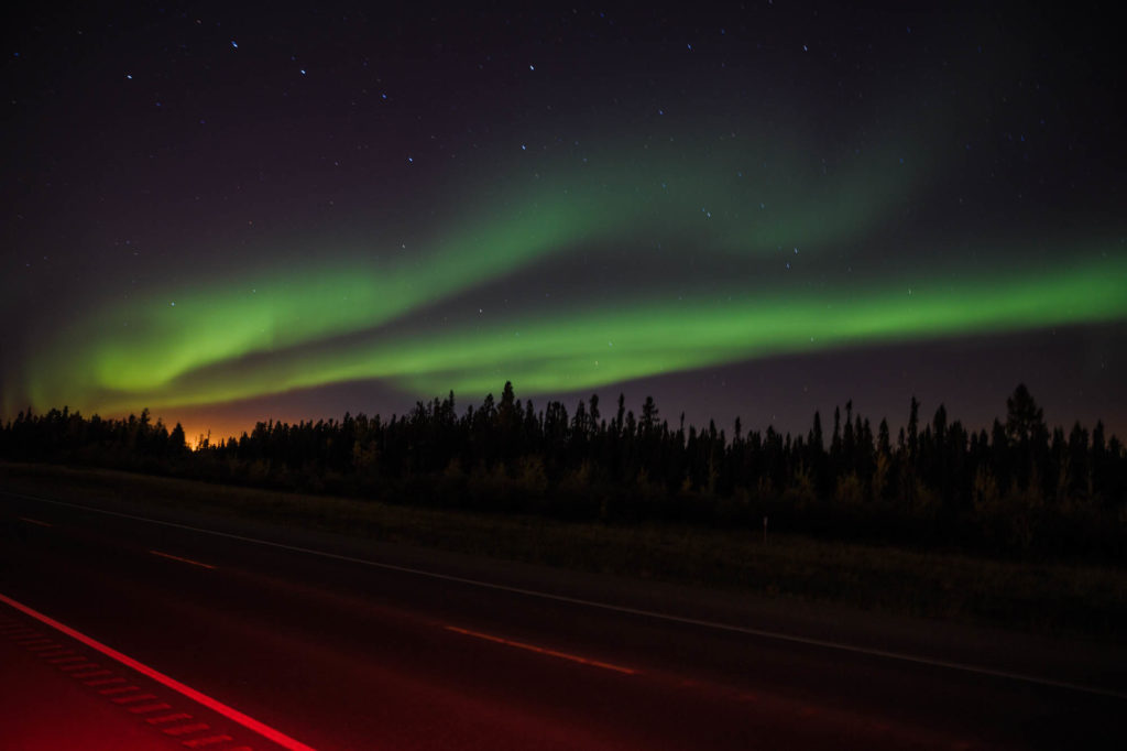 northern lights as photographed on the side of a road.